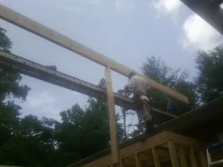 Carpenter setting a ridge beam over a new addition frame — Ice Dam Removal by Roofing Brothers in Oradell