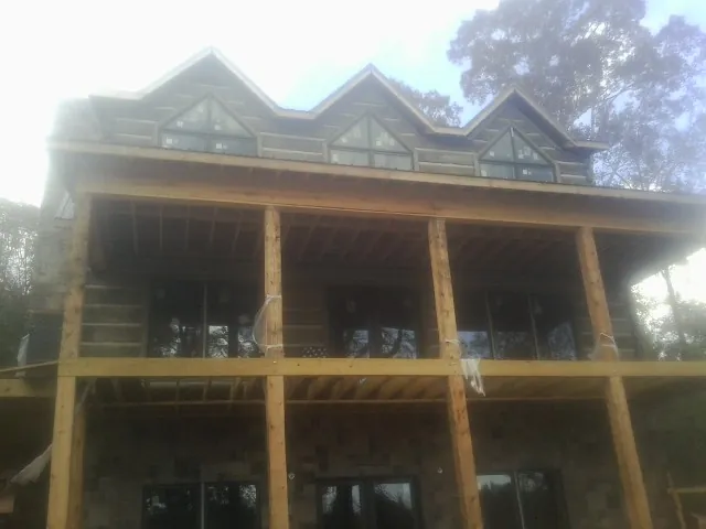 Dormers and porch framing on a large log home under construction — Roof Coating work by our crew in Oradell