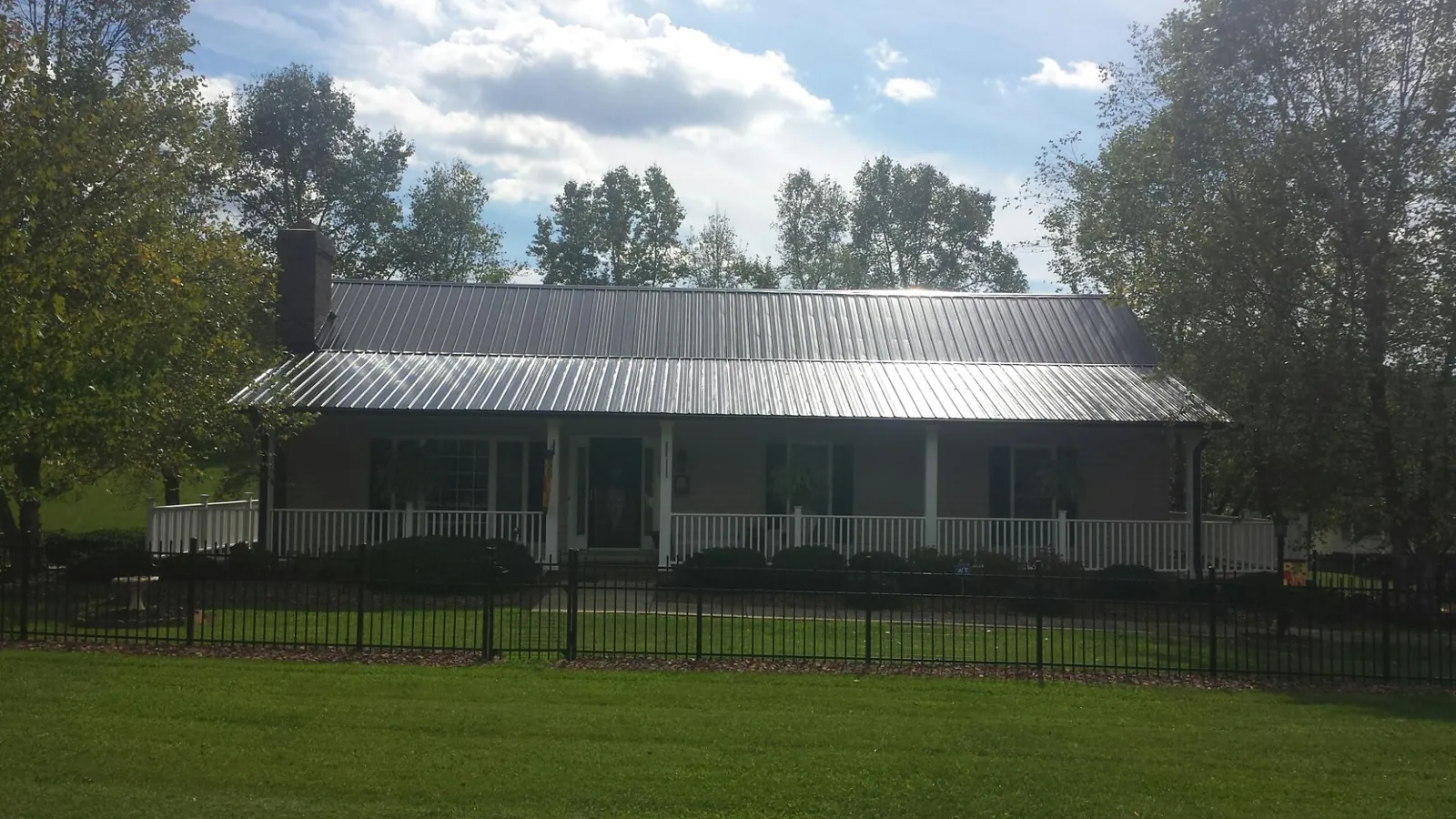 Gray metal roof on a brick ranch with a full width front porch — Gutter Guard Installation work by our crew in Oradell