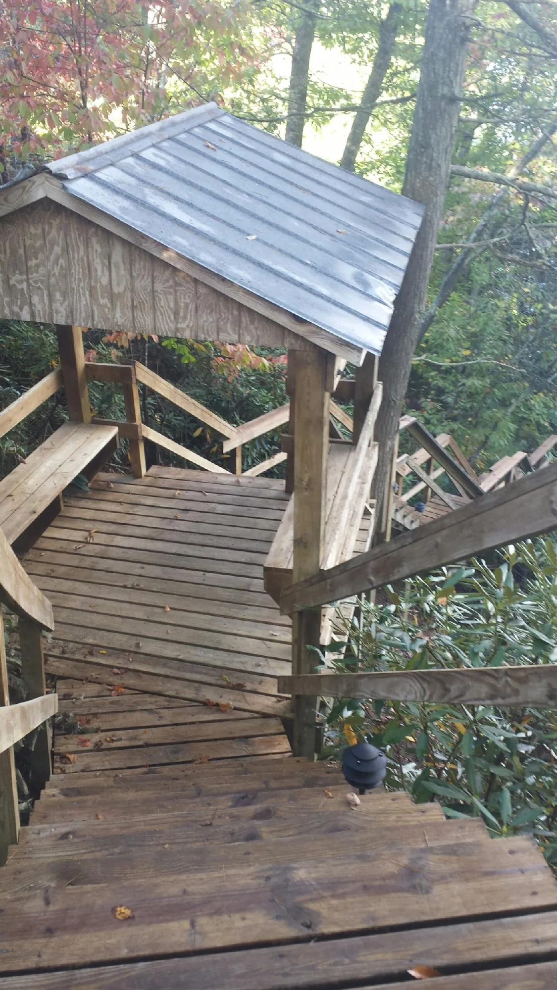 Metal roofed shelter over wooden steps on a wooded walkway — Skylight Repair & Installation work by our crew in Oradell