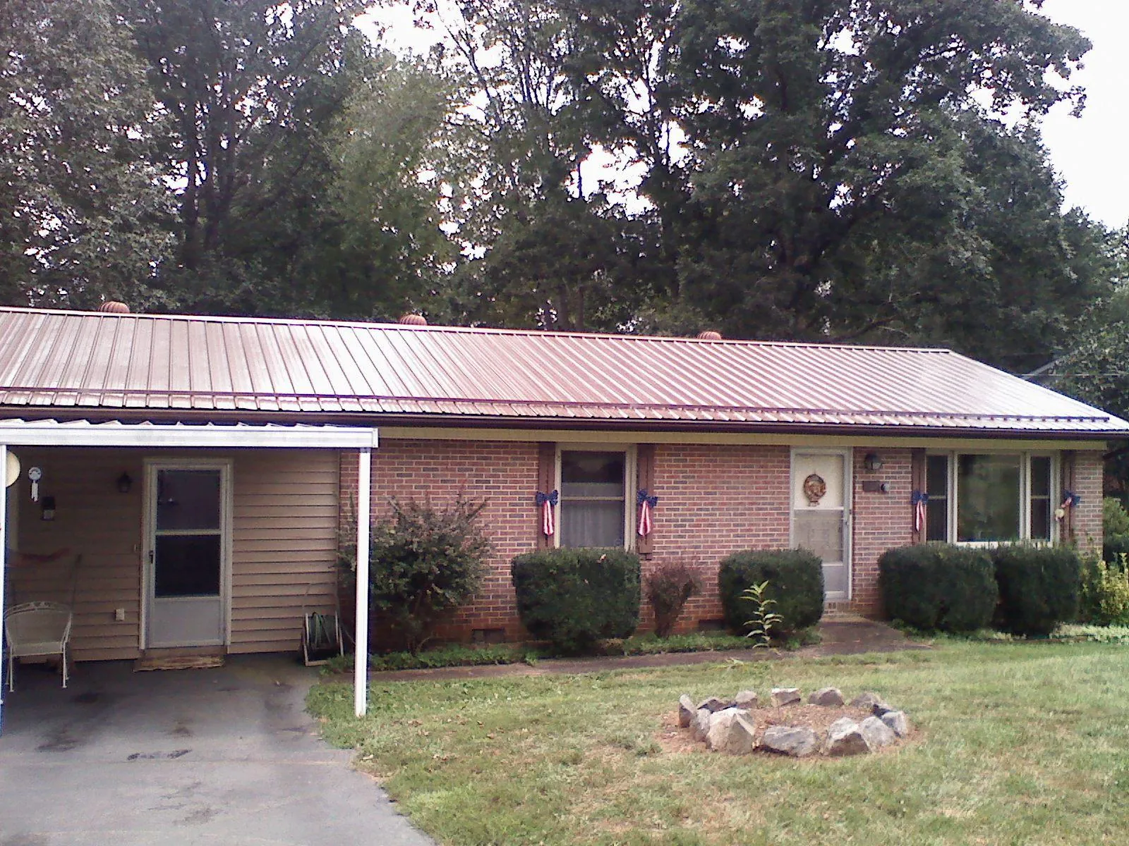 Bronze metal roof and carport on a brick ranch home — Roof Repair work by our crew in Oradell